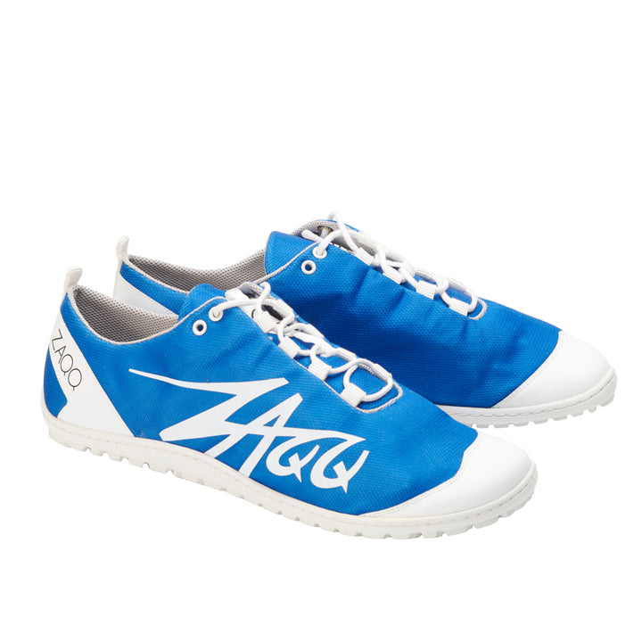 Die SQIM Azure Sneaker von ZAQQ sind ein lässiges Herrenschuhwerk in Blau und Weiß, hervorgehoben durch weiße Schnürsenkel und Sohlen. Sie verfügen über ein stilisiertes Logo an der Seite und den Markennamen ZAQQ an der Ferse. Sie sind aus atmungsaktiven Materialien für mehr Komfort gefertigt.