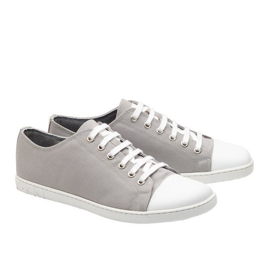 Wir präsentieren die CHUQQS Low Grey Sneaker von ZAQQ: Diese grauen Canvas-Schuhe präsentieren sich in grauem Denim-Design und sind mit weißen Gummisohlen und Schnürsenkeln versehen. Mit ihrem schlichten, lässigen Look und urbanem Stil verkörpern sie mühelosen Stil. Auf einem weißen Hintergrund dargestellt, ist ein Schuh leicht vor dem anderen positioniert, um optisch ansprechender zu wirken.