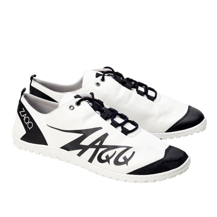 Wir präsentieren die SQIM White Black-Schuhe von ZAQQ: elegante weiße Sneaker mit schwarzen Akzenten und Schnürsenkeln, die das ZAQQ-Logo prominent an der Seite zur Schau stellen. Diese minimalistischen Schuhe sind aus nachhaltigen Recyclingfasern gefertigt und verfügen über eine strukturierte weiße Sohle für verbesserten Tragekomfort.