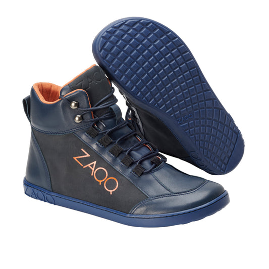 Die WALQER Navy Orange High-Top-Sneaker von ZAQQ bestechen durch ihr modisches Design mit orangefarbenem Innenfutter und Schnürsenkeln aus Premiumleder. Diese Barfußschuhe tragen den Markennamen prominent auf der Seite und sind mit einer strukturierten blauen Sohle für besseren Halt ausgestattet.