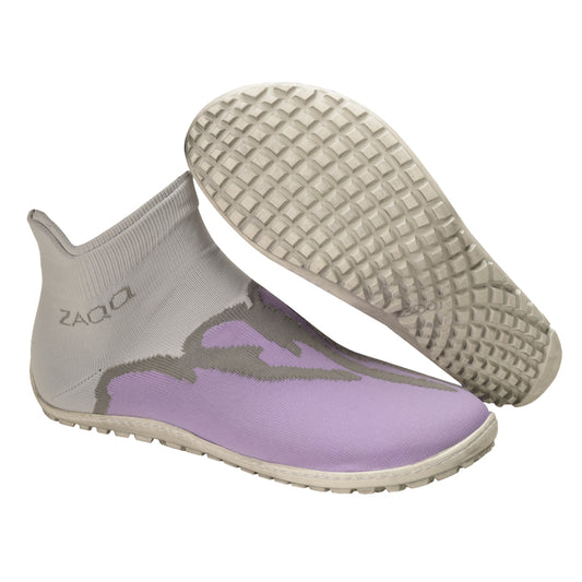 Die stylischen SOQQ Fire Purple Sockenschuhe von ZAQQ präsentieren sich in einem modernen, sockenähnlichen Design. Sie haben ein graues Obermaterial, das mit dem ZAQQ SOQQ Fire Purple-Branding verziert und mit lavendelfarbenen Details akzentuiert ist, während ihre strukturierte Sohle für hervorragenden Halt sorgt. Ein Schuh wird aufrecht neben einem anderen ausgestellt, der schräg steht, um das einzigartige Sohlenmuster hervorzuheben.