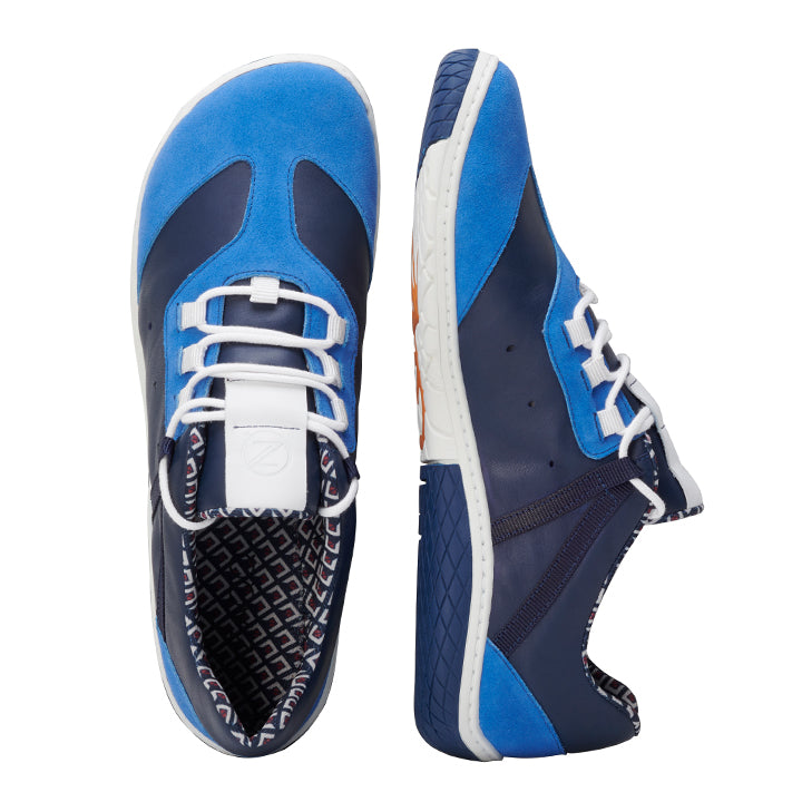 Wir präsentieren die QOAST Blue-Sneaker von ZAQQ, die eine stilvolle Kombination aus Blau und Marineblau mit weißen Schnürsenkeln aufweisen. Diese Barfußschuh-Sneaker aus Nappaleder zeigen eine Seitenansicht des linken Schuhs und eine Draufsicht des rechten Schuhs. Im Inneren zeigen sie ein Futter mit geometrischem Muster und verfügen über eine strukturierte Sohle für besseren Halt.