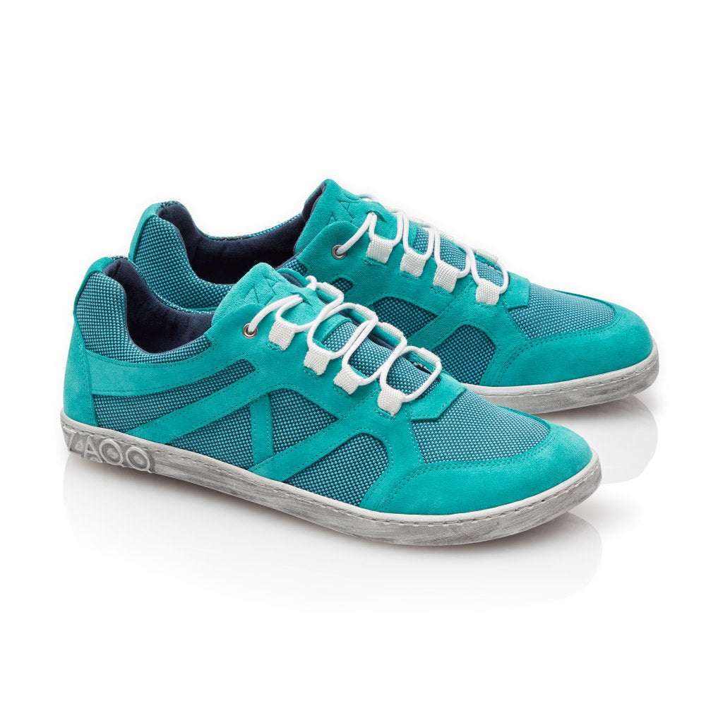 Wir präsentieren den QUSQO Turquoise von ZAQQ: Diese türkisfarbenen Sneaker mit weißen Schnürsenkeln und grauen Sohlen bieten eine Mesh- und Wildleder-ähnliche Textur. Mit ihrem modernen Design und den grafischen Mustern an den Seiten auf weißem Hintergrund sorgen sie für ein „atmungsaktives“ Erlebnis und ultimativen Komfort.