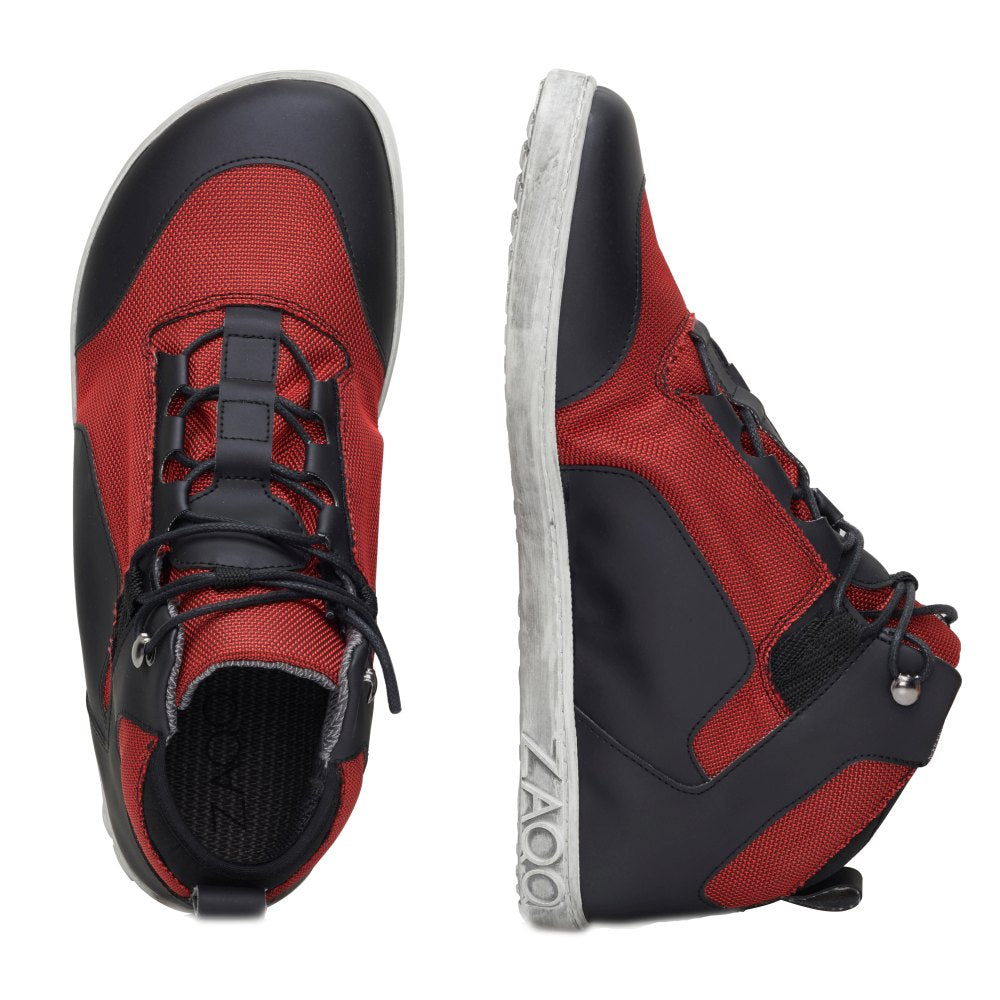 Die RAQO Black Red Sneaker von ZAQQ werden präsentiert, einer von der Seite und der andere aus der Luft. Sie haben ein rot-schwarzes Design mit schwarzen Schnürsenkeln, weißen Sohlen und dem Markennamen ZAQQ an der Seite. Diese veganen Schuhe verbinden nahtlos Stil mit Nachhaltigkeit.