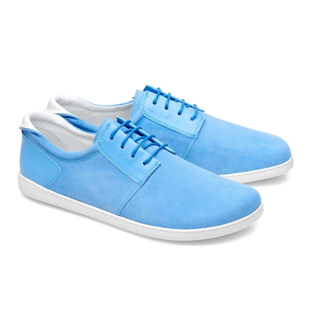 Ein Paar PIQUANT Pool Sneaker von ZAQQ aus hochwertigem Veloursleder in leuchtendem Blau, mit weißer Sohle und Schnürsenkeln, nebeneinander angeordnet und von der Seite betrachtet. Das Design ist lässig und modern.