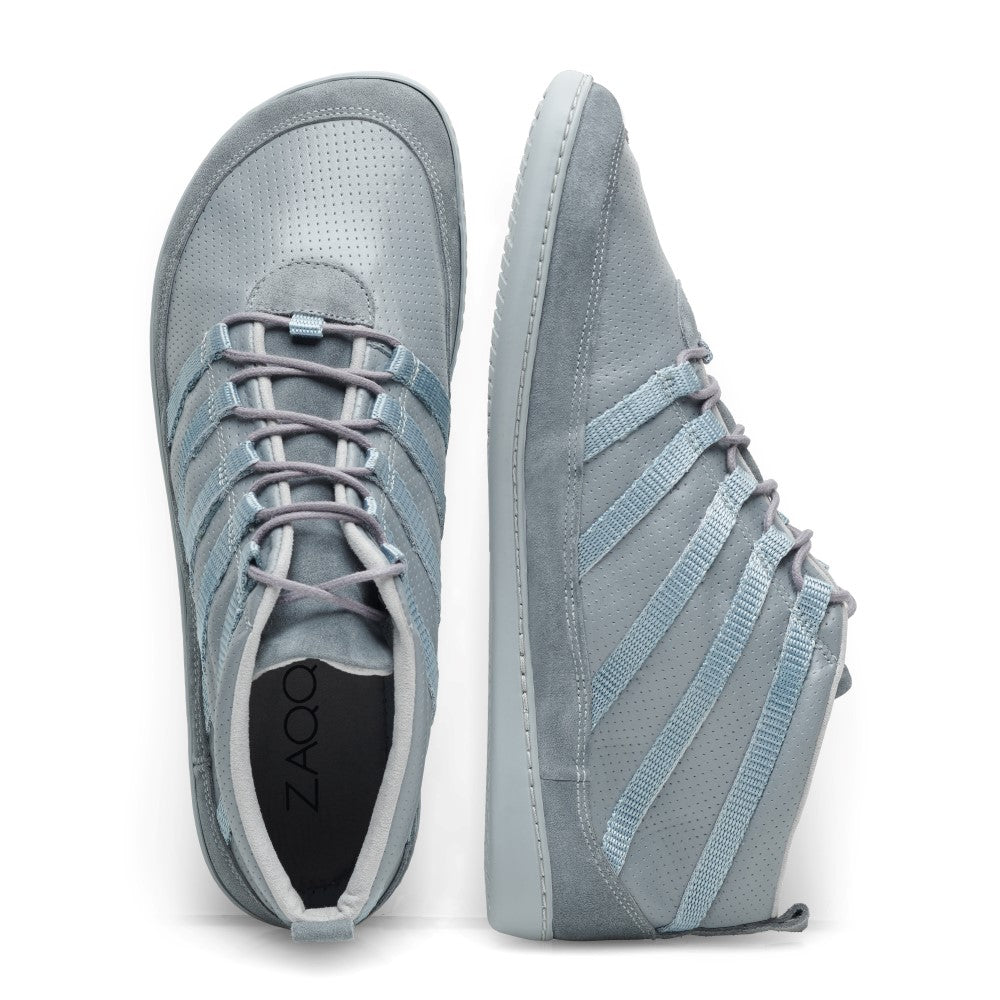 Die SPARQ Mid Grey Sneaker von ZAQQ sind aus geschmeidigem Nappaleder gefertigt und in Draufsicht und Seitenansicht präsentiert. Diese hellblauen Schnürschuhe verfügen über eine perforierte Textur auf dem Obermaterial für mehr Komfort sowie mehrere Schnürsenkel auf jeder Seite als Designdetail. Die glatte Sohle ist weiß.