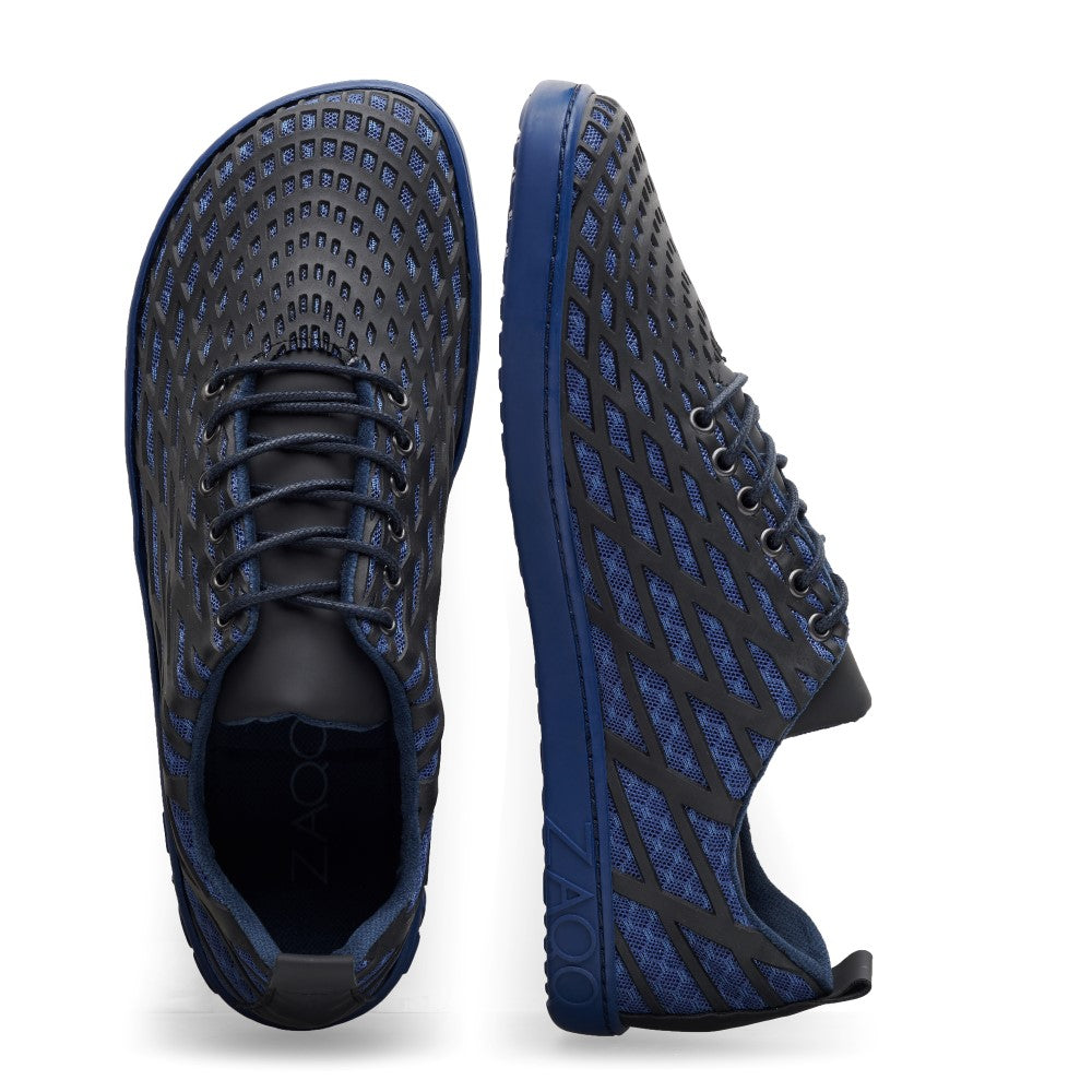 Wir präsentieren die ZAQQ SPIQE Blue Black Sneaker mit einem dunkelblauen und schwarzen Musterdesign und Gittermuster für noch mehr Attraktivität. Diese veganen Schuhe bieten den typischen Barfußschuh-Komfort. Sie zeigen sowohl ihr schickes Seitenprofil mit Schnürsenkeln als auch ihre einzigartig strukturierte Sohle und protzen mit einem schlanken Nullabsatz-Profil.